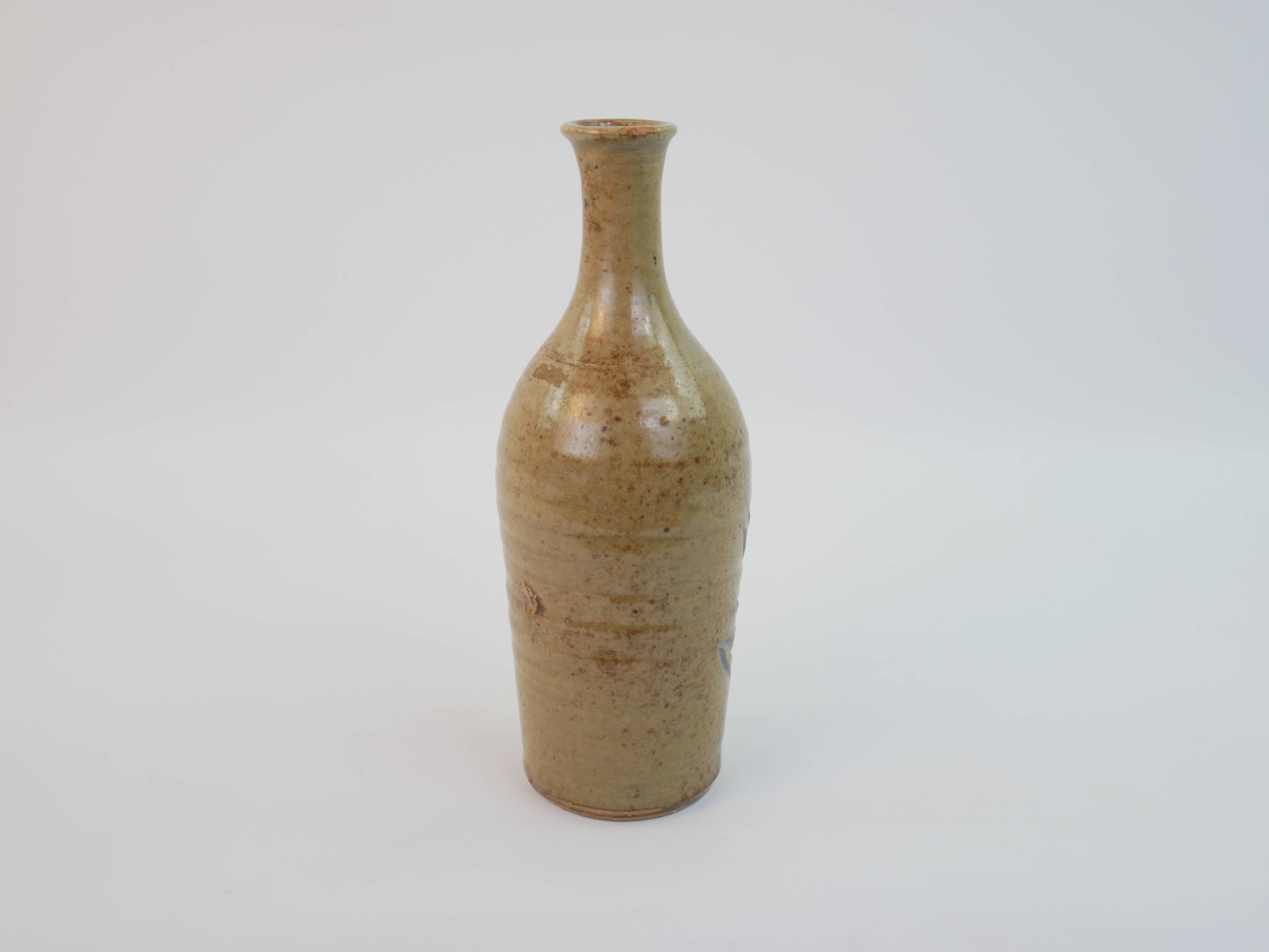 Brown ceramic/stoneware bottle with chiseled floral pattern
