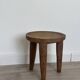 Antique stool made of raw wood carved from a single trunk