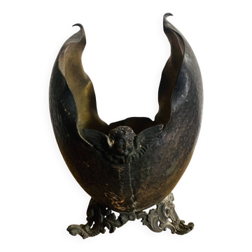 Antique decorative cup in hammered metal with putto design.