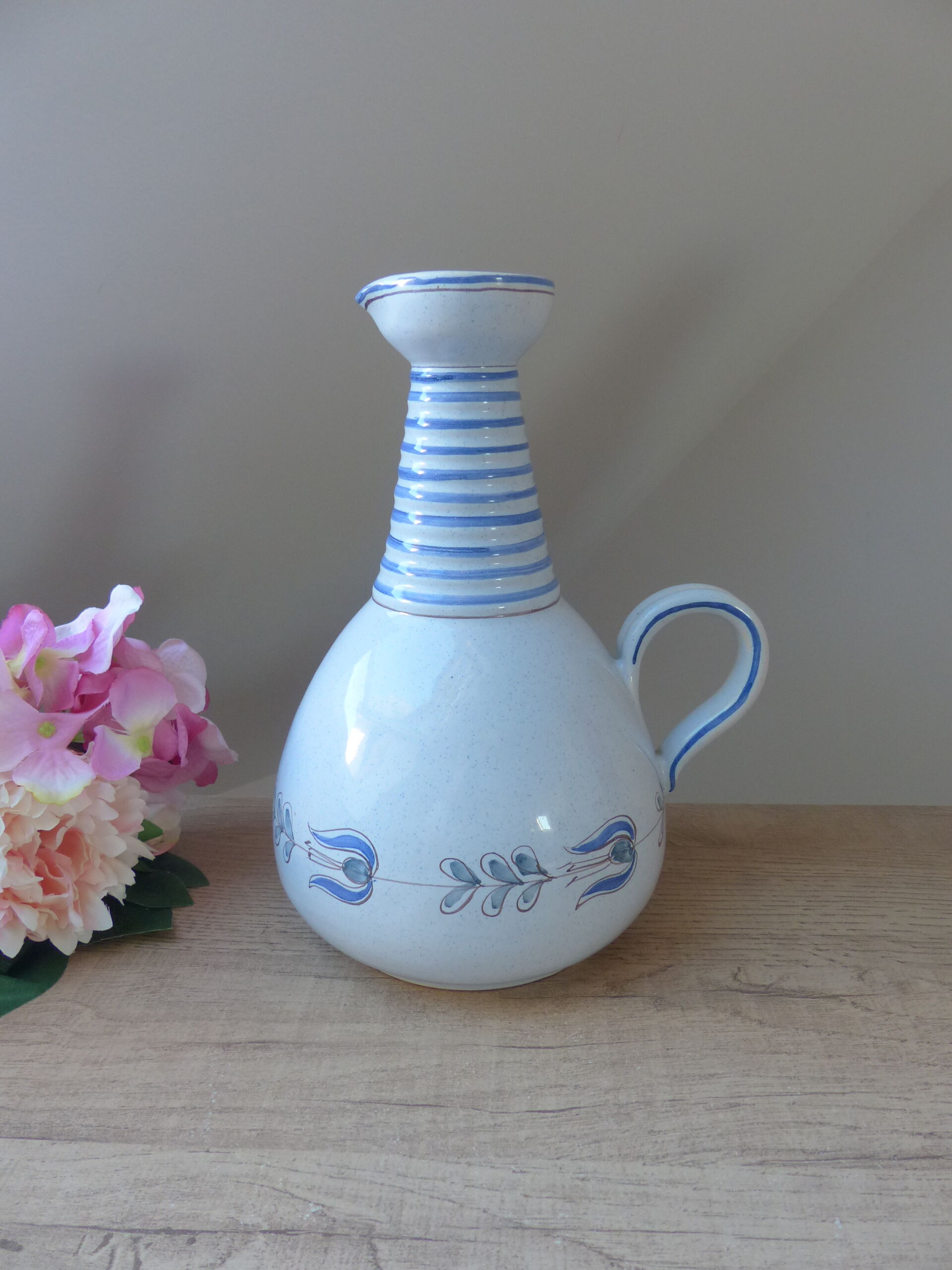 Vintage blue ceramic jug with hand-painted floral decoration.