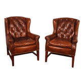 Fauteuils Chesterfield en cuir marron avec accoudoirs en ailes.