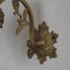 Simple wall sconce in French Art Nouveau bronze with a white glass shade featuring patterns.