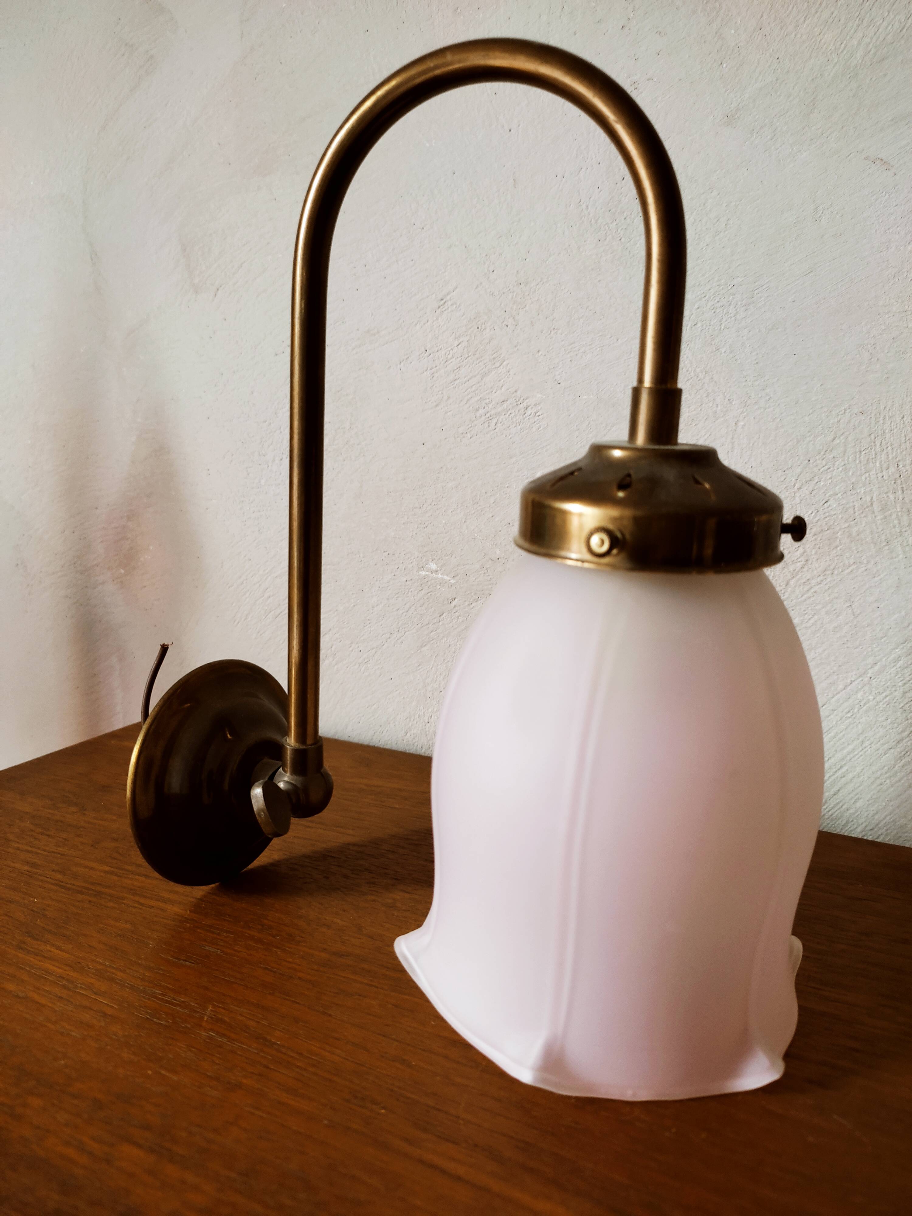 Brass wall lamp with pale pink bell