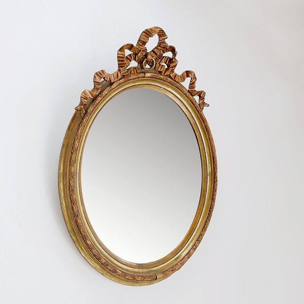 Wear consistent with age and use  Wood and gilded plaster ''Noeud d'Amour'' Oval mirror