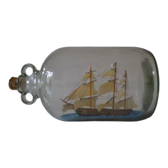 Old diorama sailboat in large glass bottle
