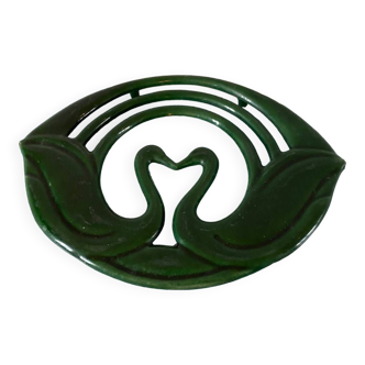Enamelled cast iron trivet with sign decoration.