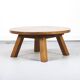 Large rustic vintage coffee table in a round brutalist style.