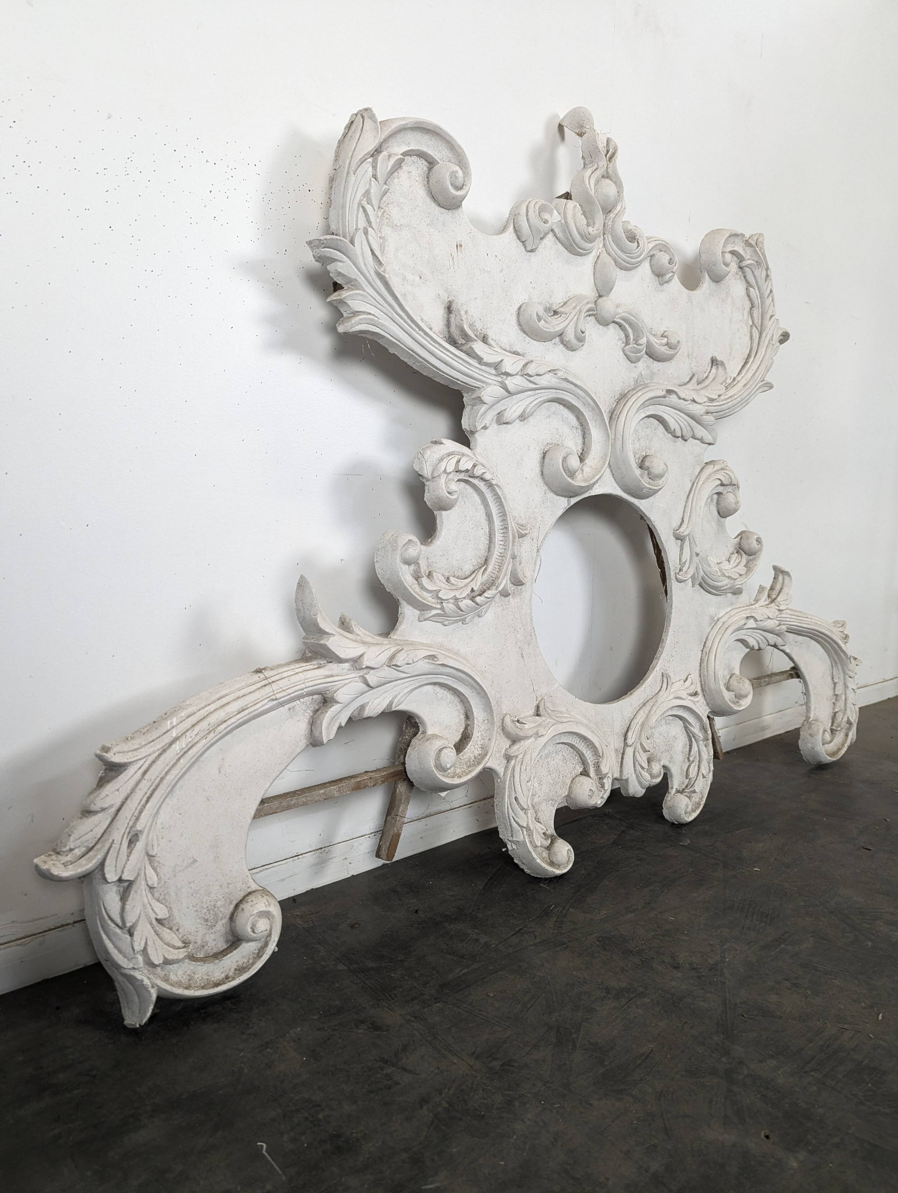 Large rococo fronton in stucco and carved wood, patinated white with an oculus.