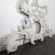 Large rococo fronton in stucco and carved wood, patinated white with an oculus.