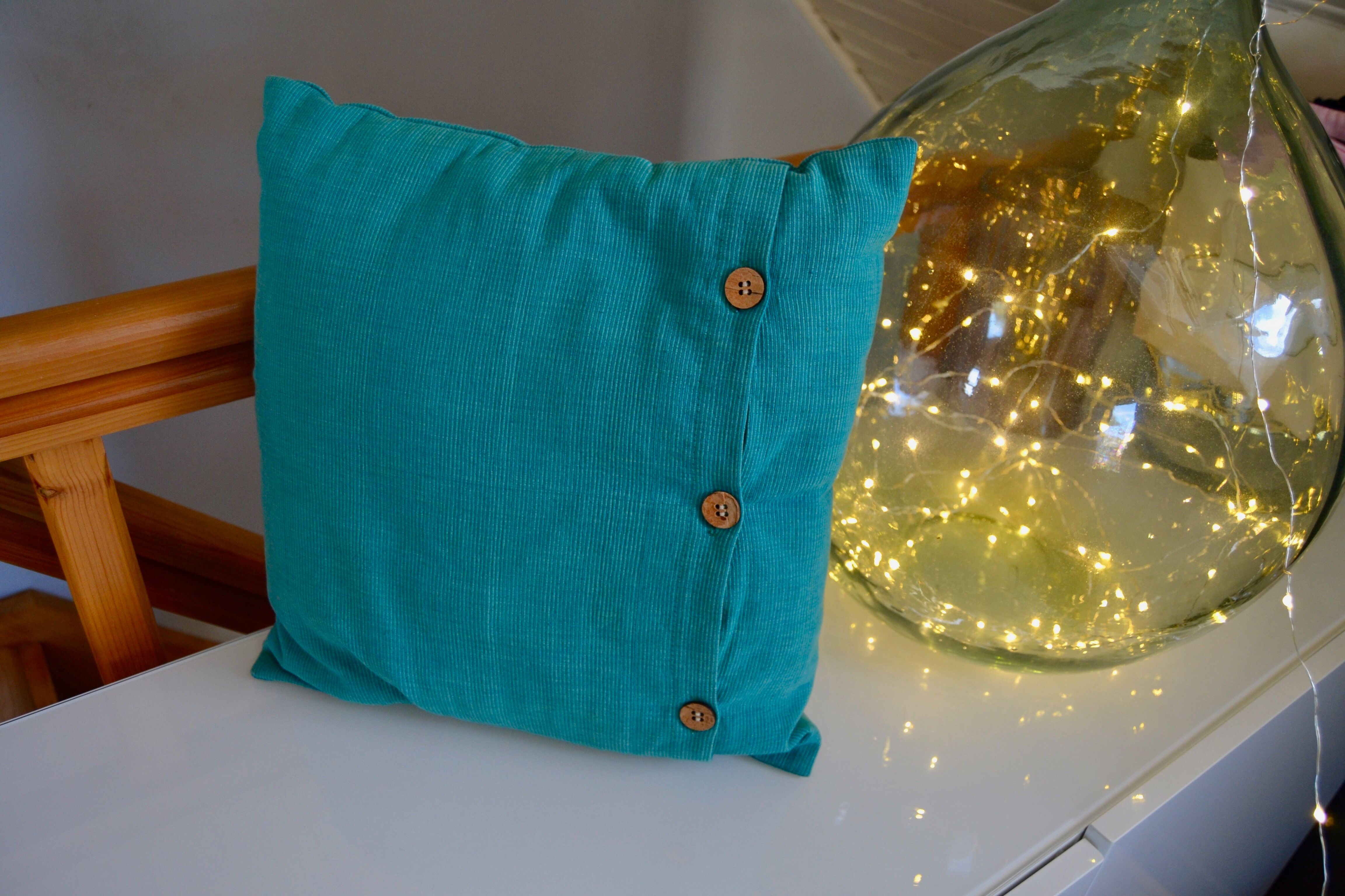 Scandinavian green cushion with wooden buttons