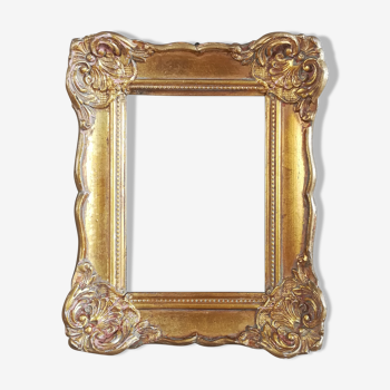 Patinated golden frame in wood and stucco