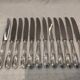 12 silver-plated metal table knives with rocaille ribbon decoration, 25.1 cm