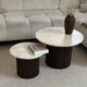 Round nesting coffee table in travertine and dark fluted wood.