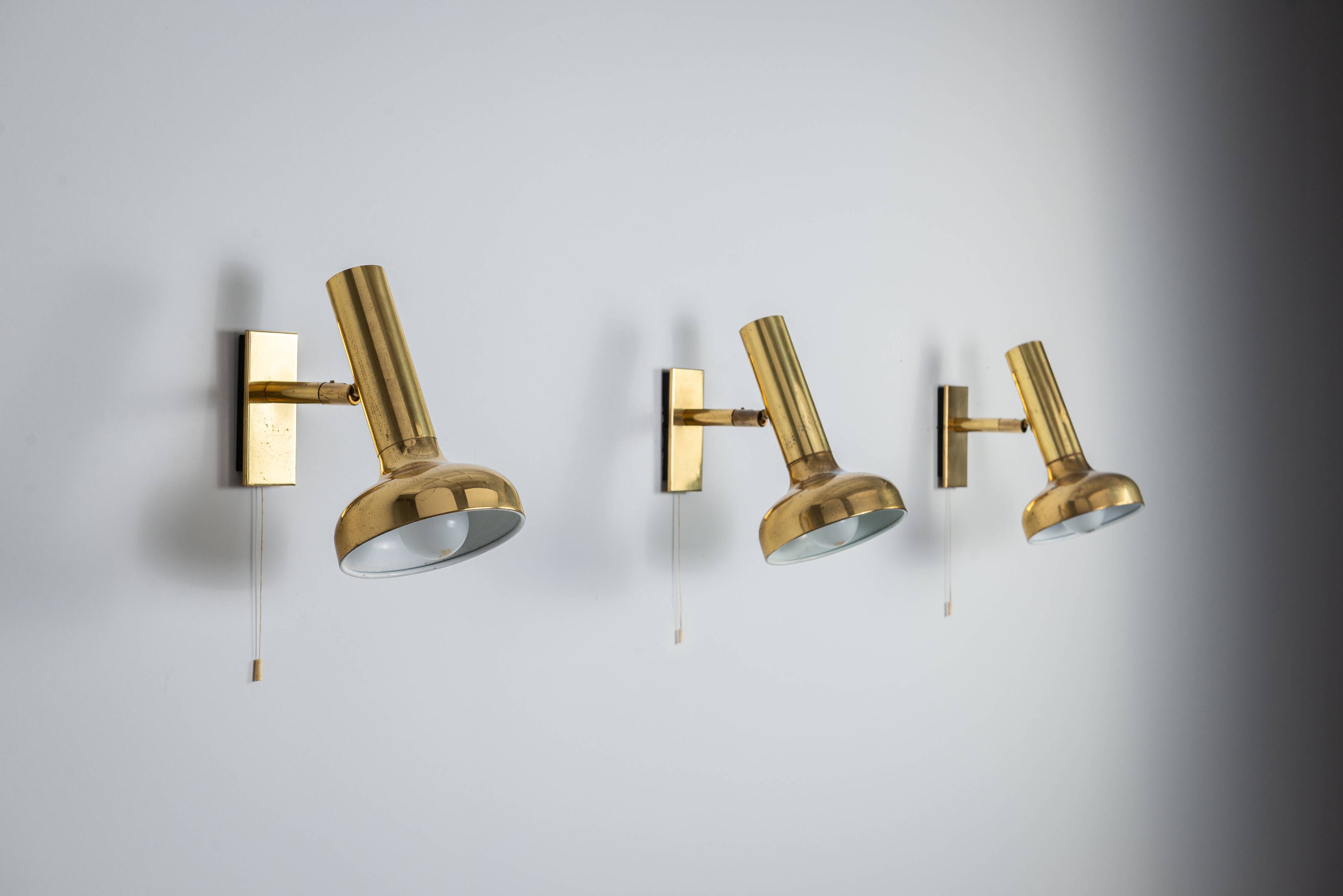 Set of three brass adjustable wall lamps