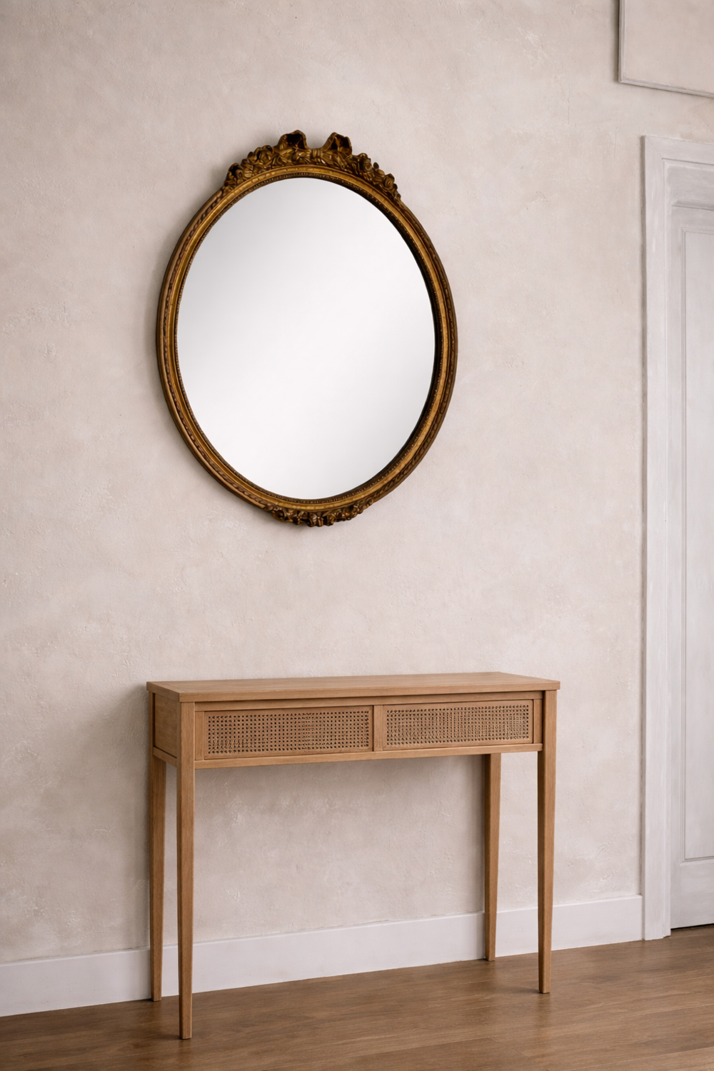 Antique oval mirror in Louis XVI style, gilded, with a bow pediment, 55cm.