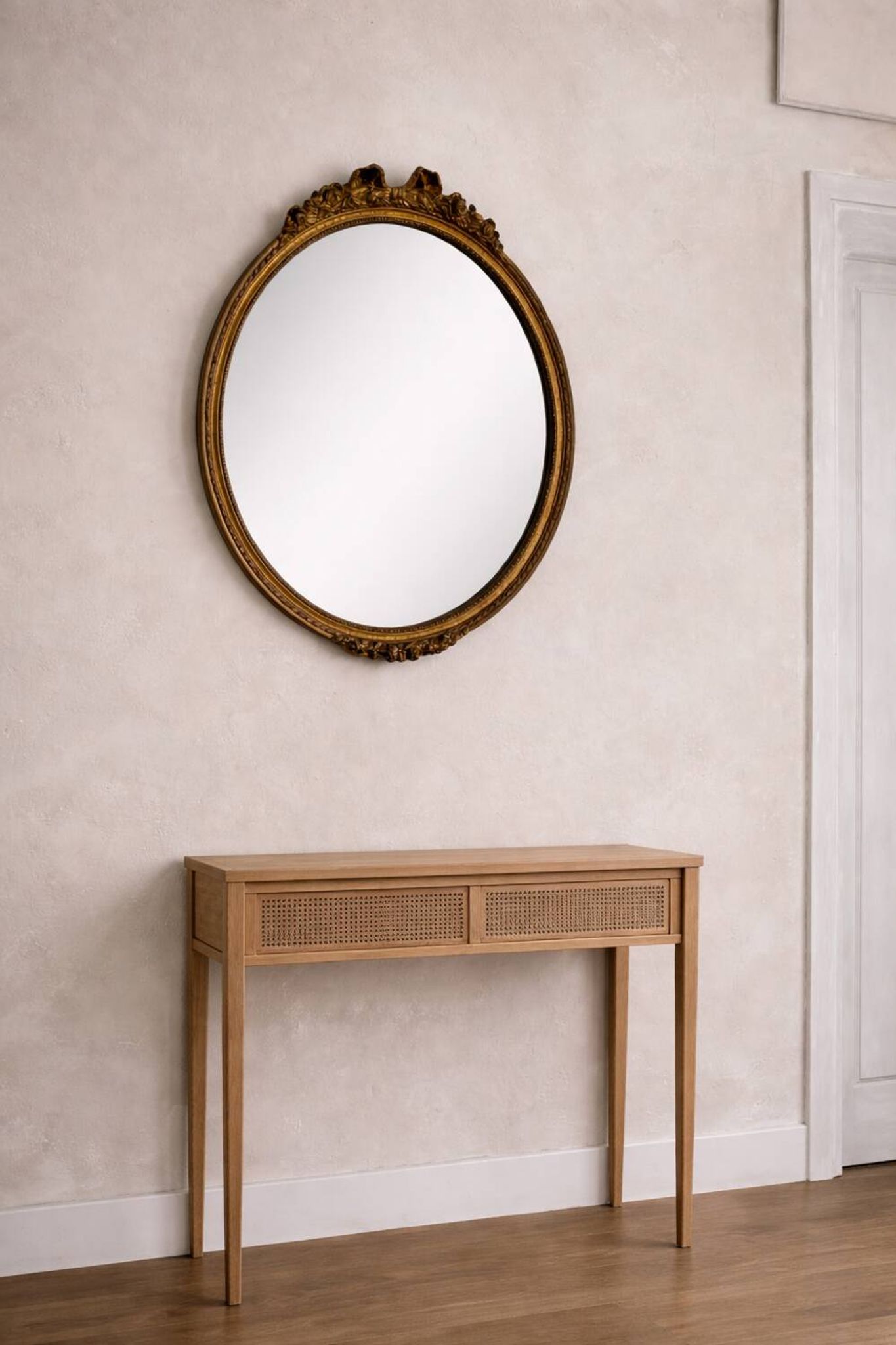 Antique oval mirror in Louis XVI style, gilded, with a bow pediment, 55cm.