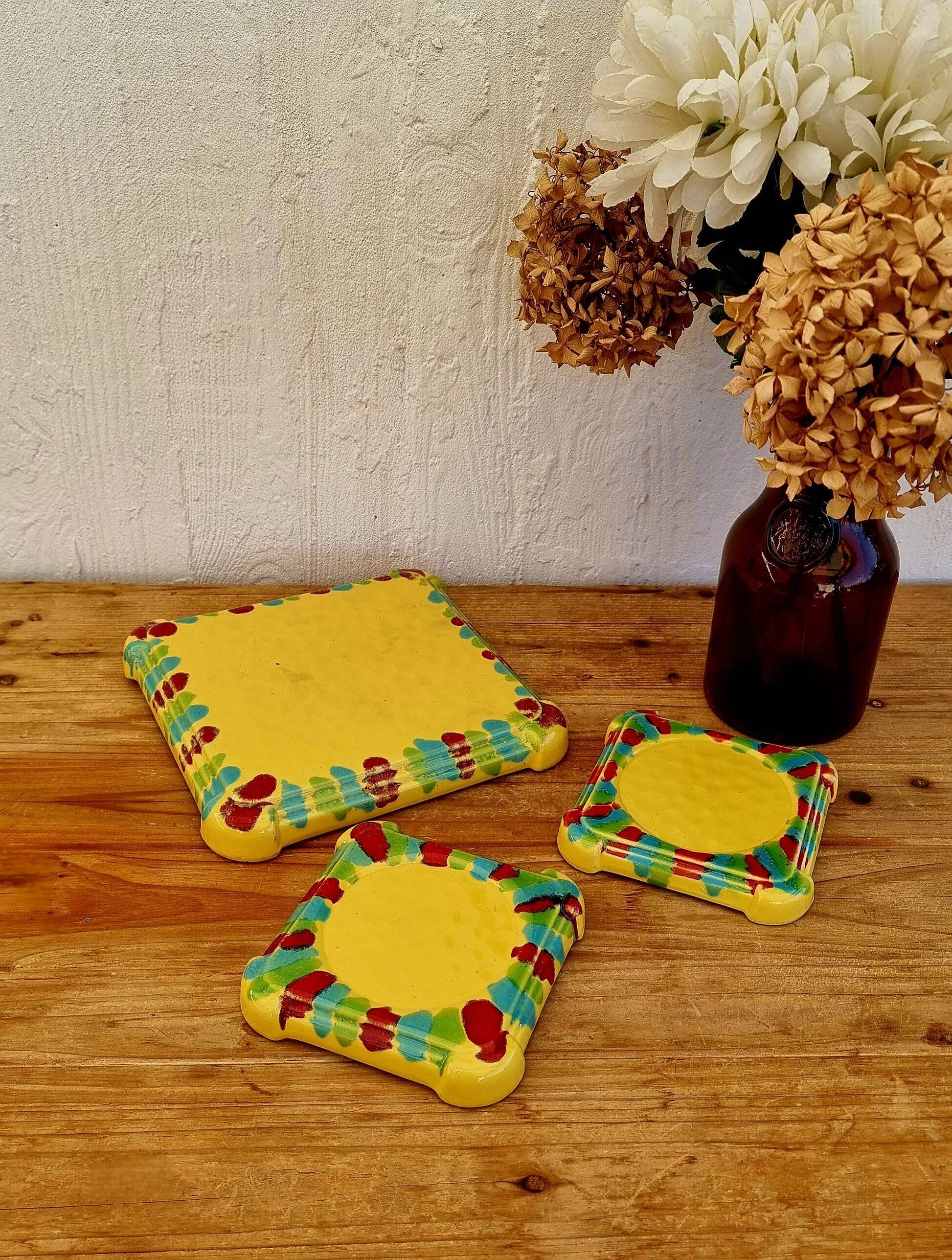 Yellow ceramic trivet and bottle coaster with vintage painted decoration.