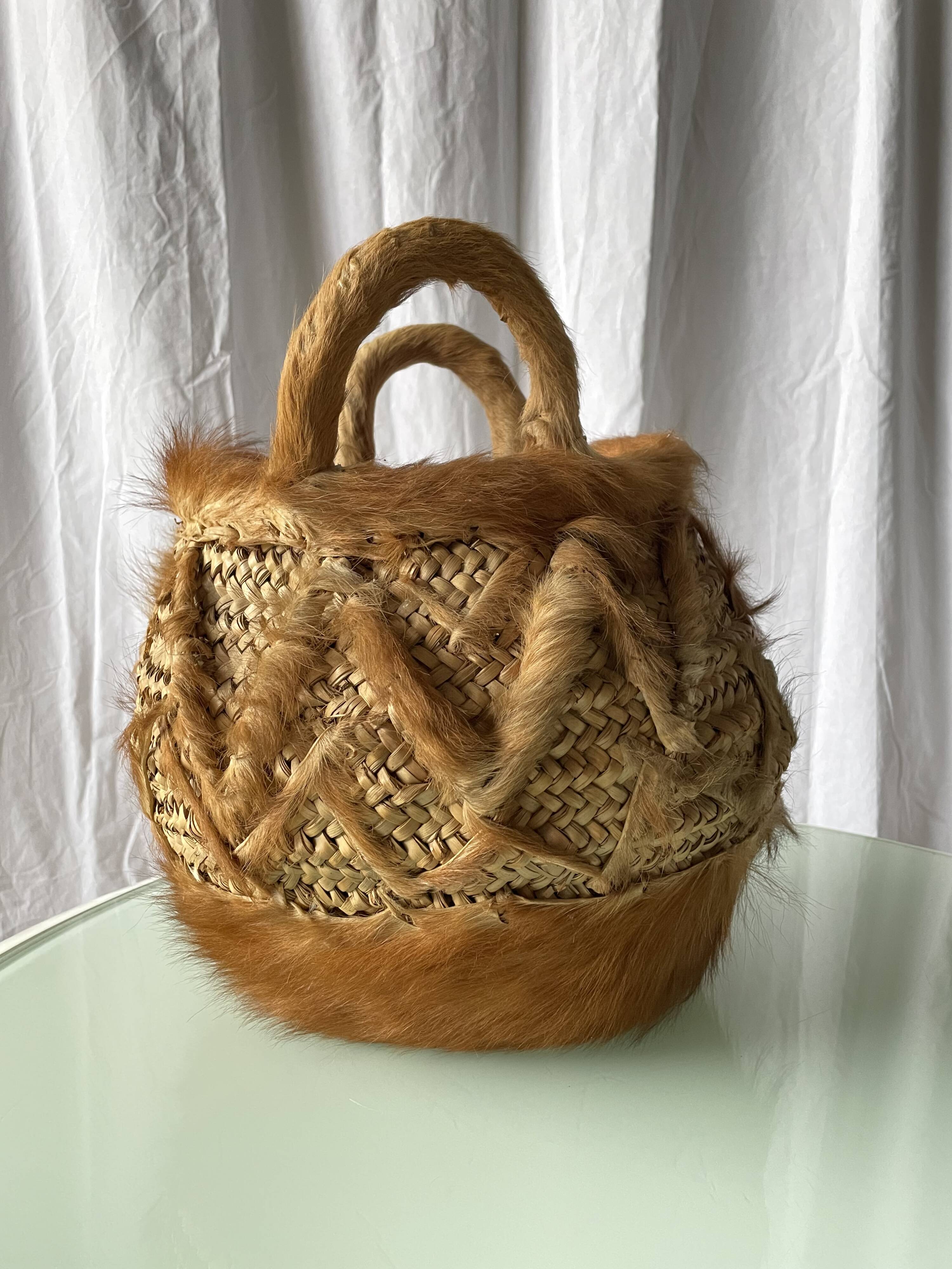 Handwoven vintage basket with handles made from natural fibres.