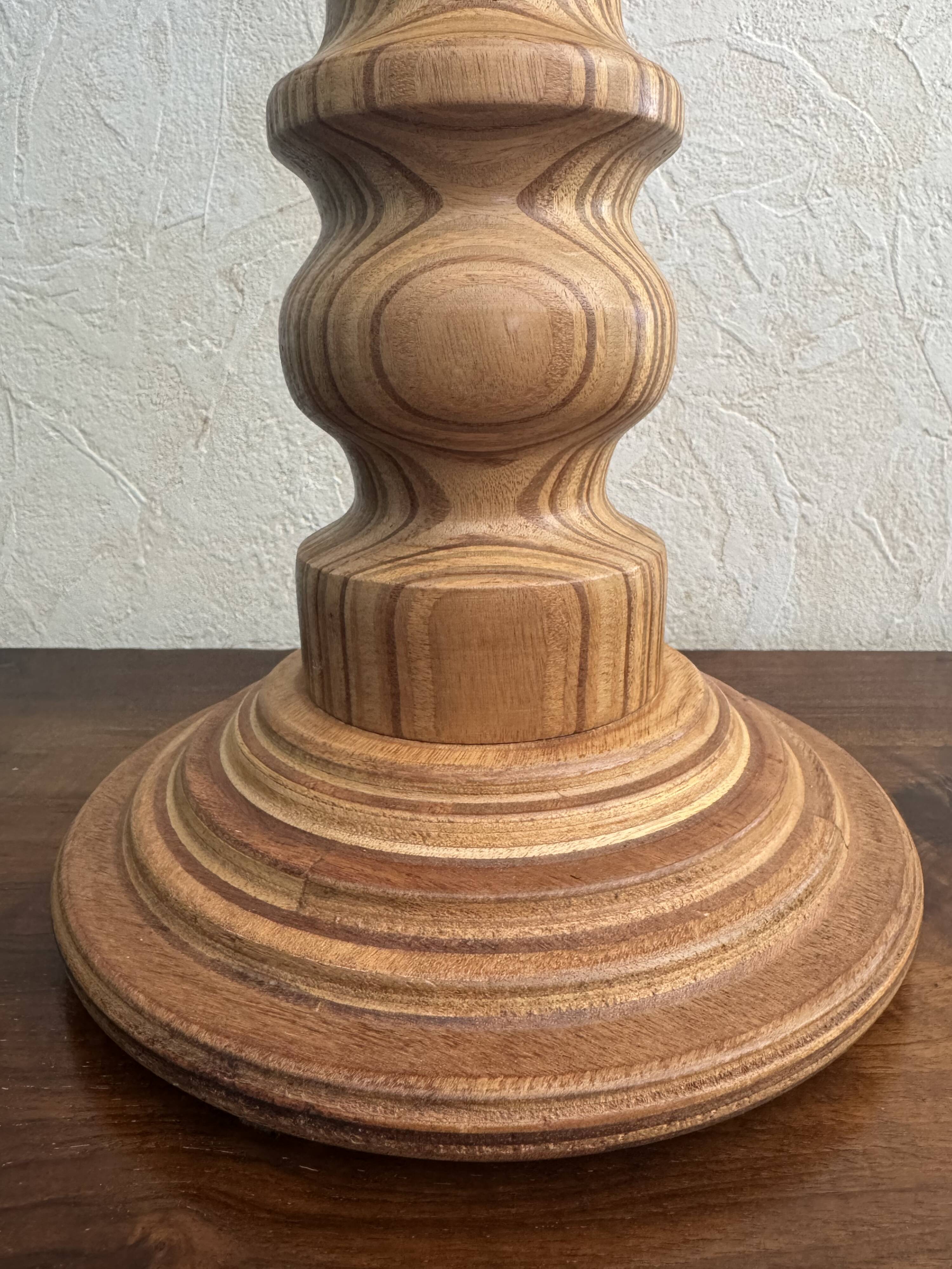 Wooden turned totem lamp with a linen shade in a vintage Scandinavian style.