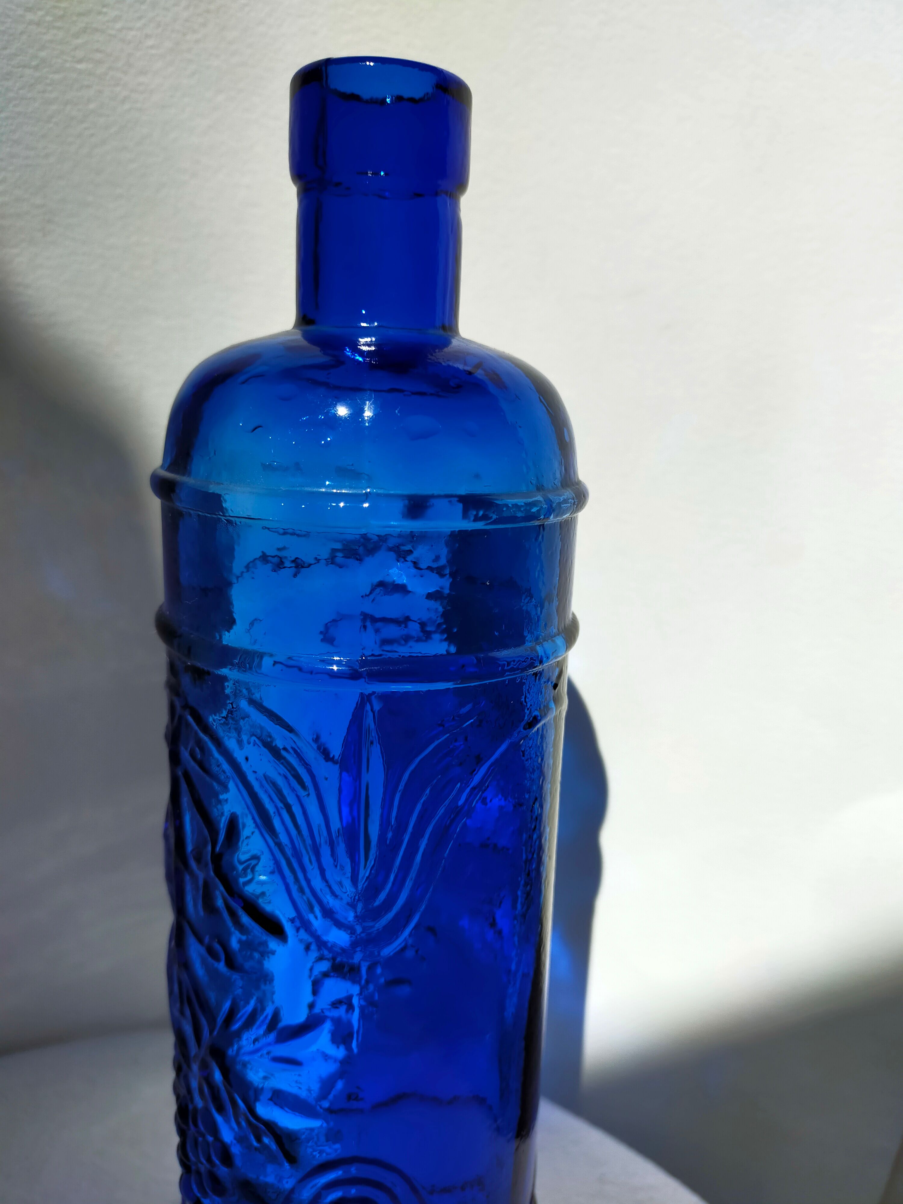 cobalt blue molded glass bottle in relief decoration bunches of grapes