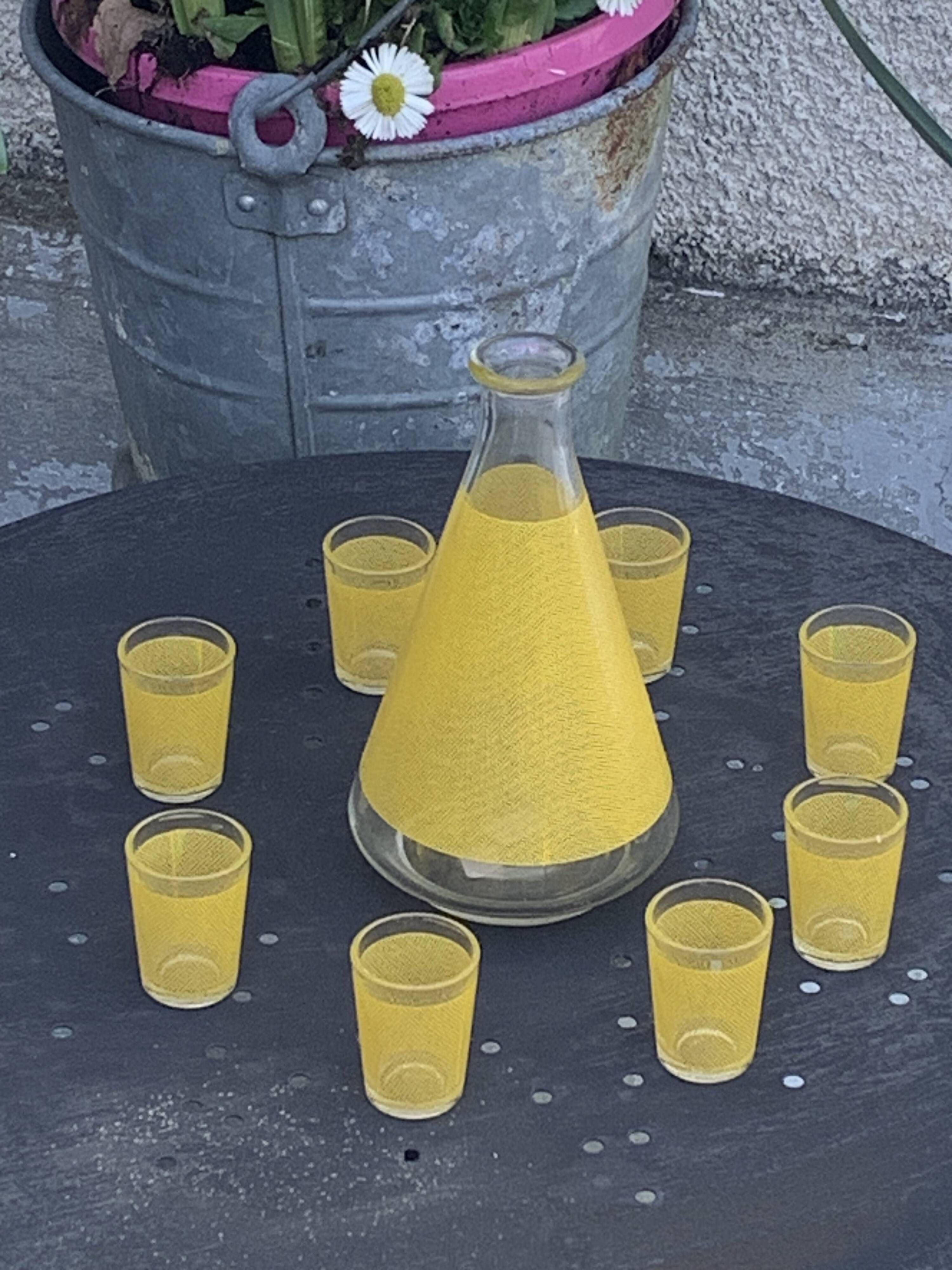 Liqueur service composed of a glass carafe and 8 small yellow screen-printed glasses