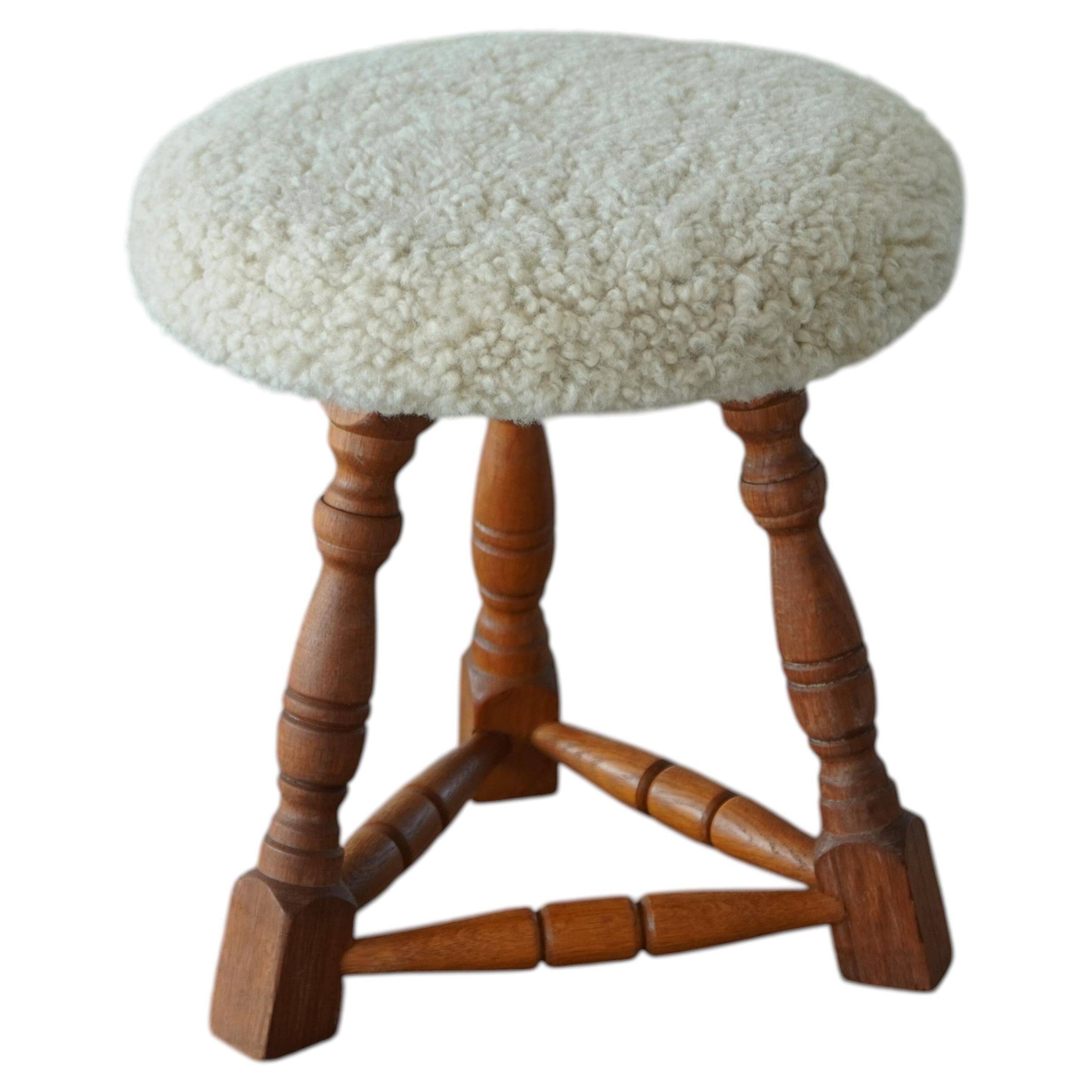 Modern Danish stool, with three oak legs featuring turned feet and a lambswool seat, 1950s.