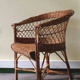 Woven rattan armchair with armrests.