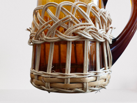 Fruit juice or vintage lemonade service in glass and wicker.