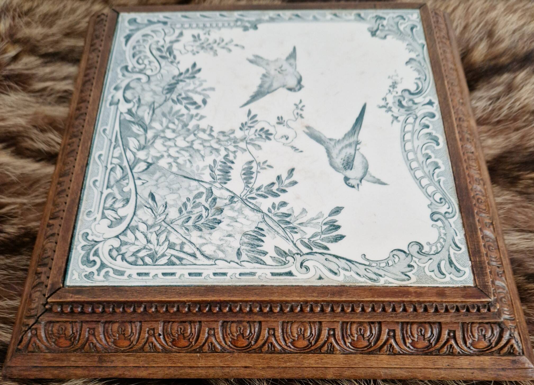Antique musical trivet made of carved wood and Belle Époque earthenware.