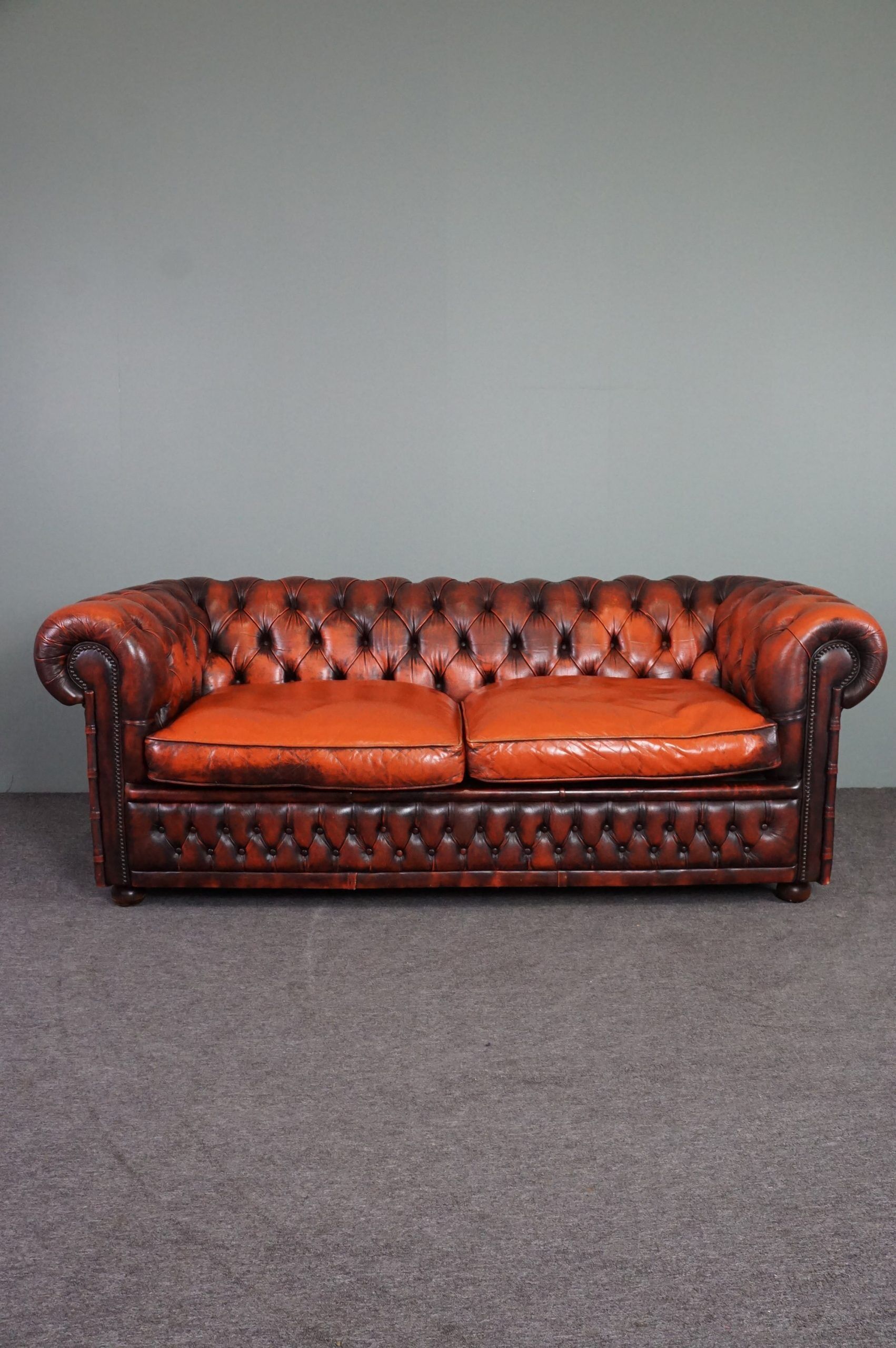 Chesterfield sofa in patinated orange leather, 2.5 seats
