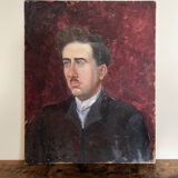 Old oil painting on cardboard portrait of a man in a dark suit