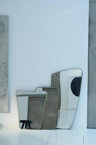 Contemporary rectangular mirror with rounded edges and embossed brass frame.