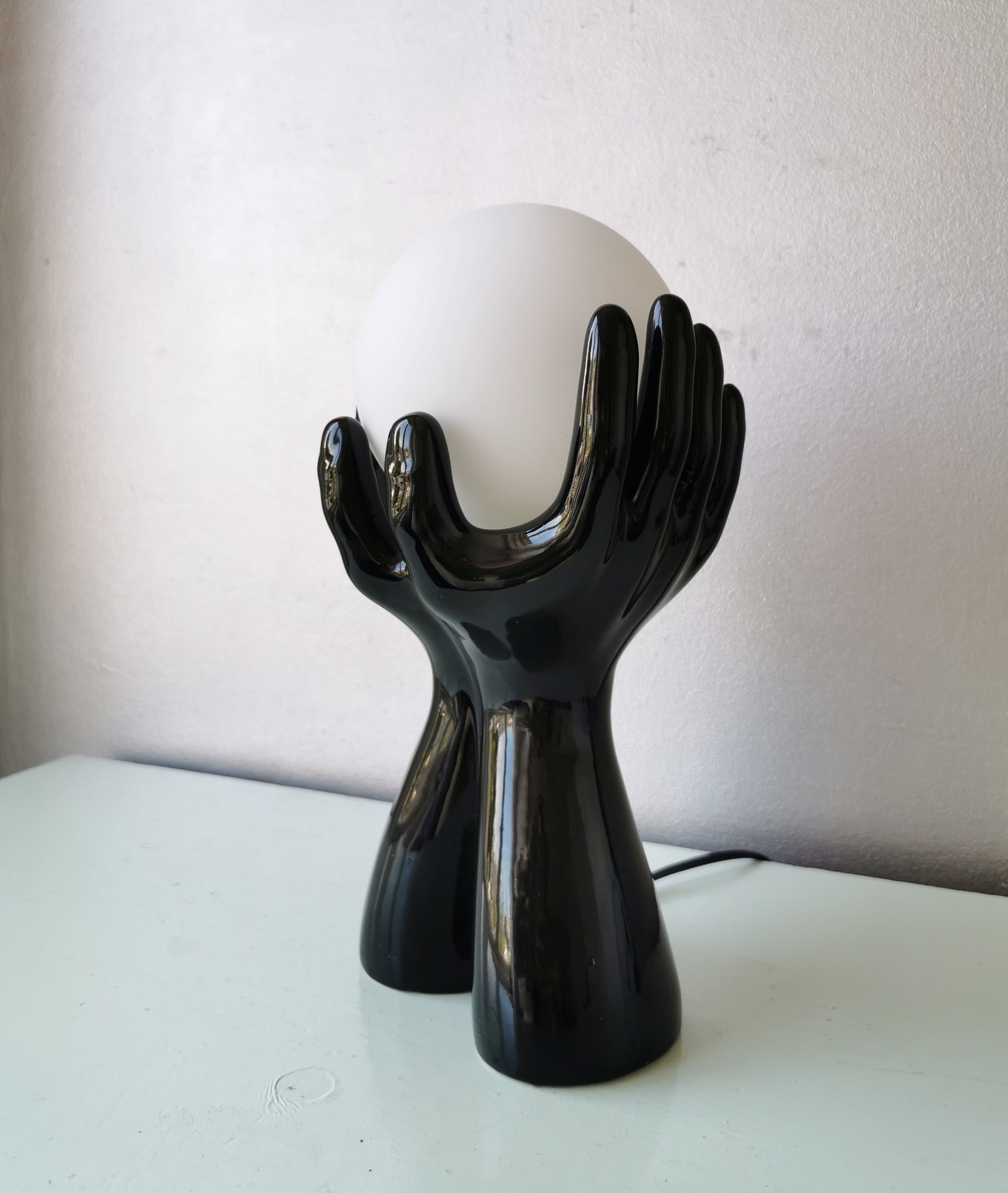 Italian design ceramic table lamp, two hands and glass shade.