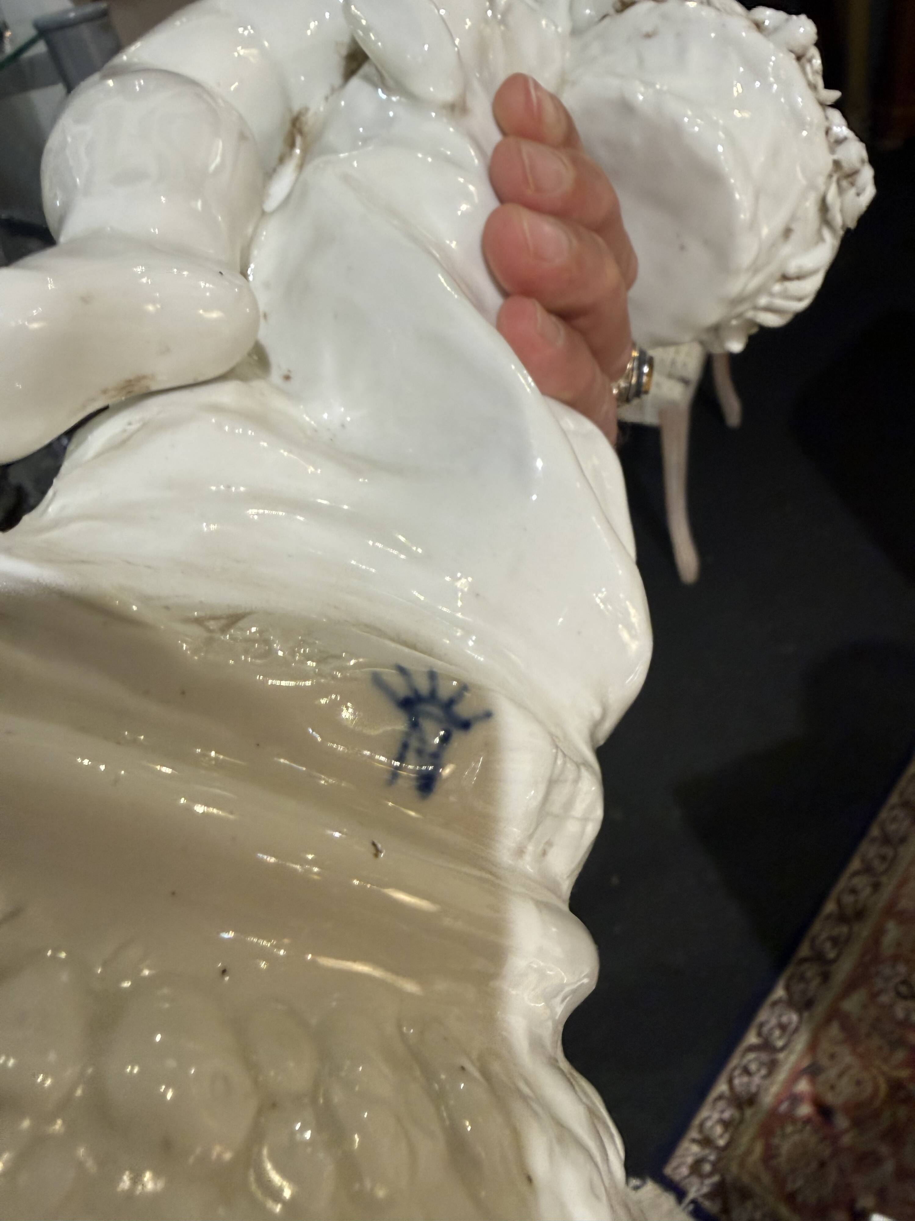 Child statue with flowers in porcelain, signed.