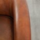 Sheepskin club armchair with a cognac colour finished with decorative nails