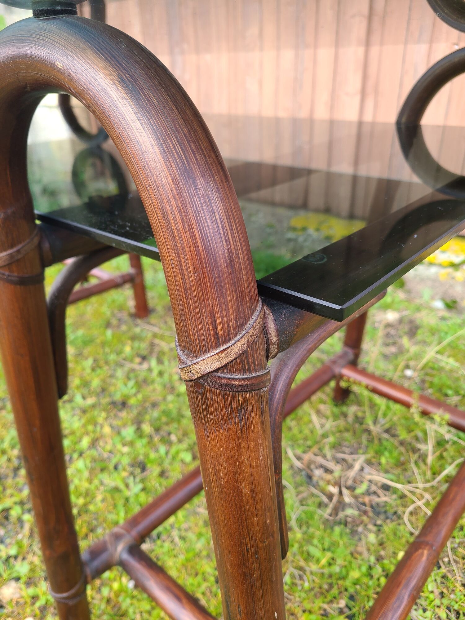 Smoked glass desk on rattan legs and leather detail