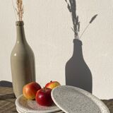 4 black speckled dessert plates on a vintage white background