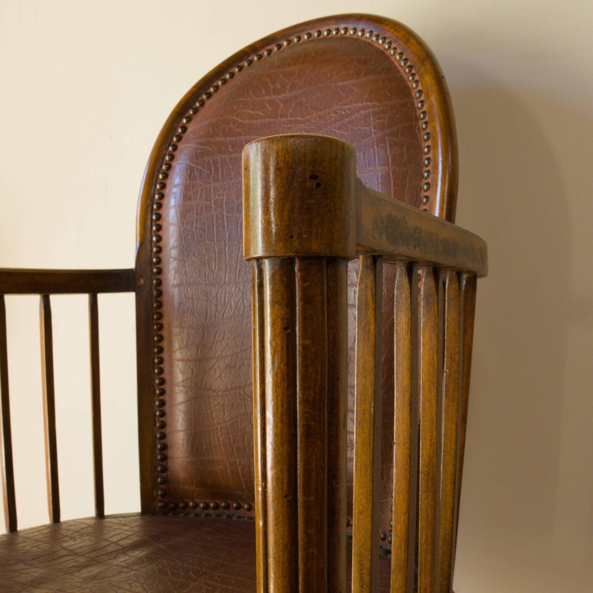 Antique armchair in solid wood and patinated brown leather, early 20th century.
