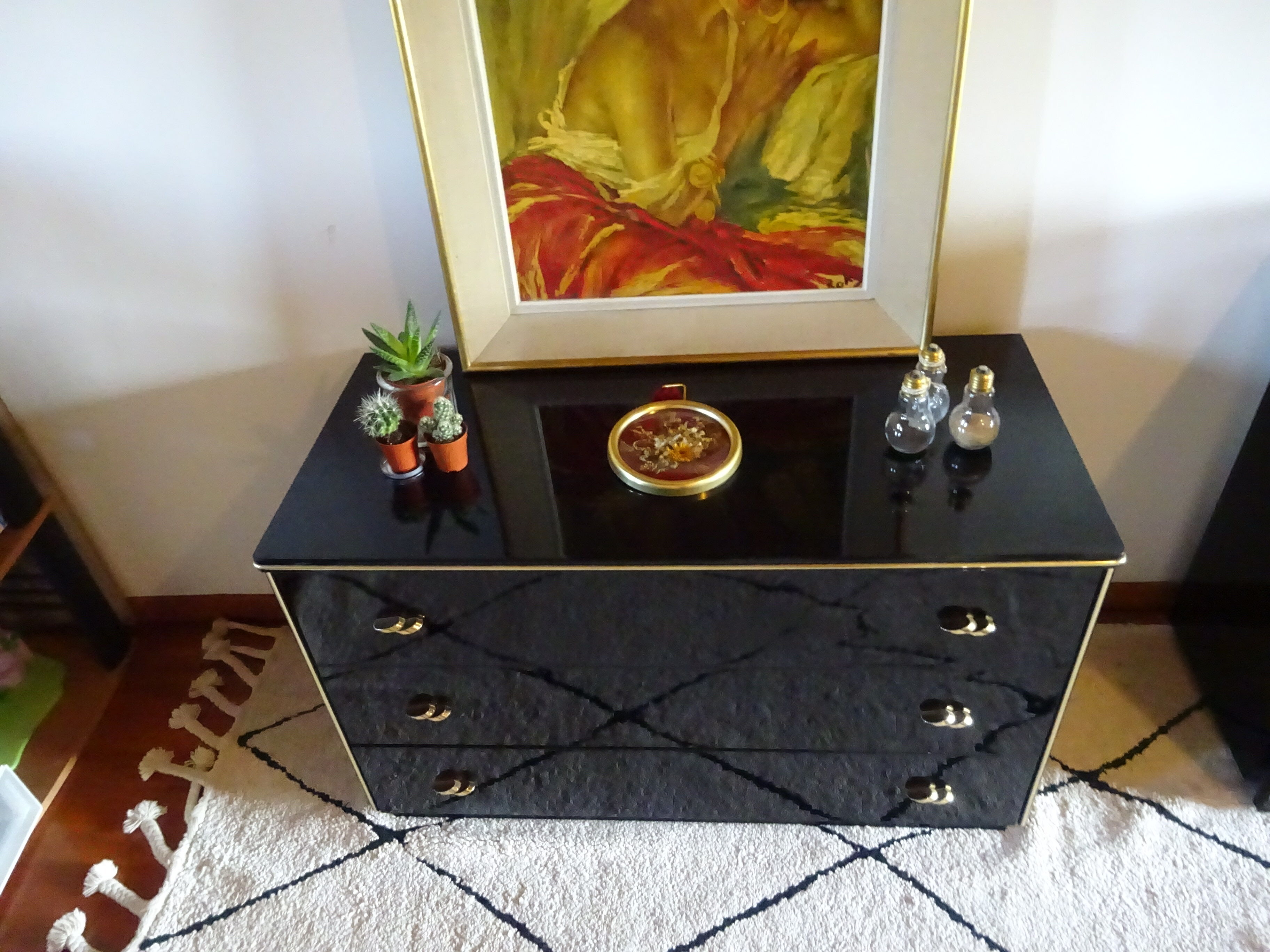Lacquered black chest of drawers, golden brass