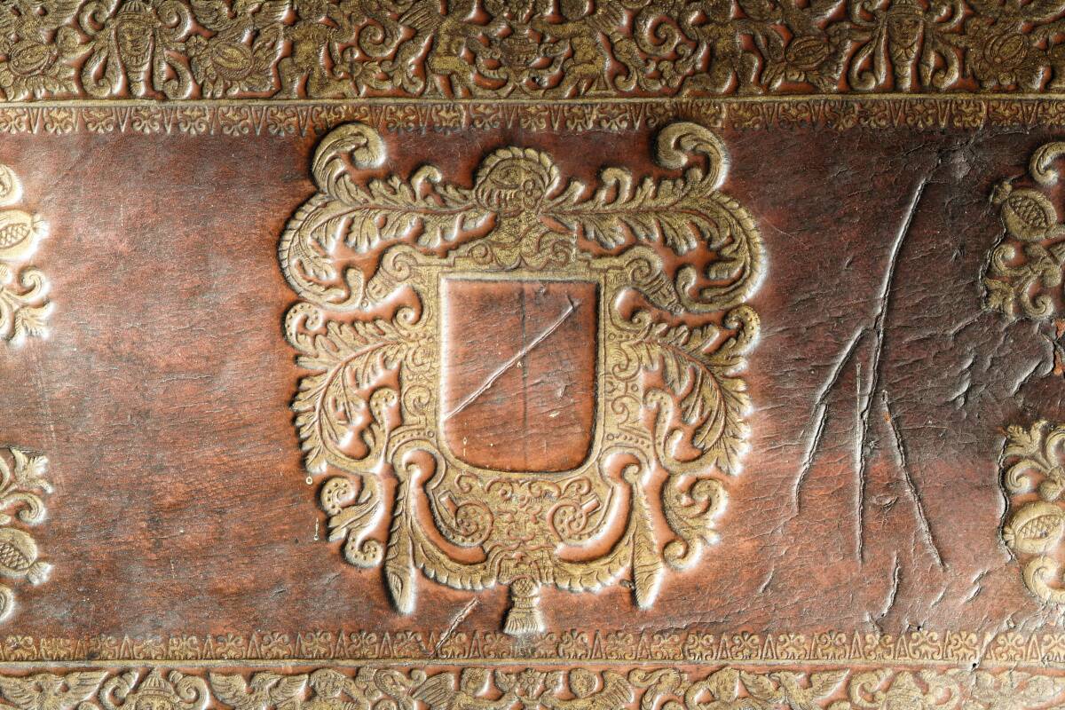 Antique armchair in walnut and studded leather, 17th century