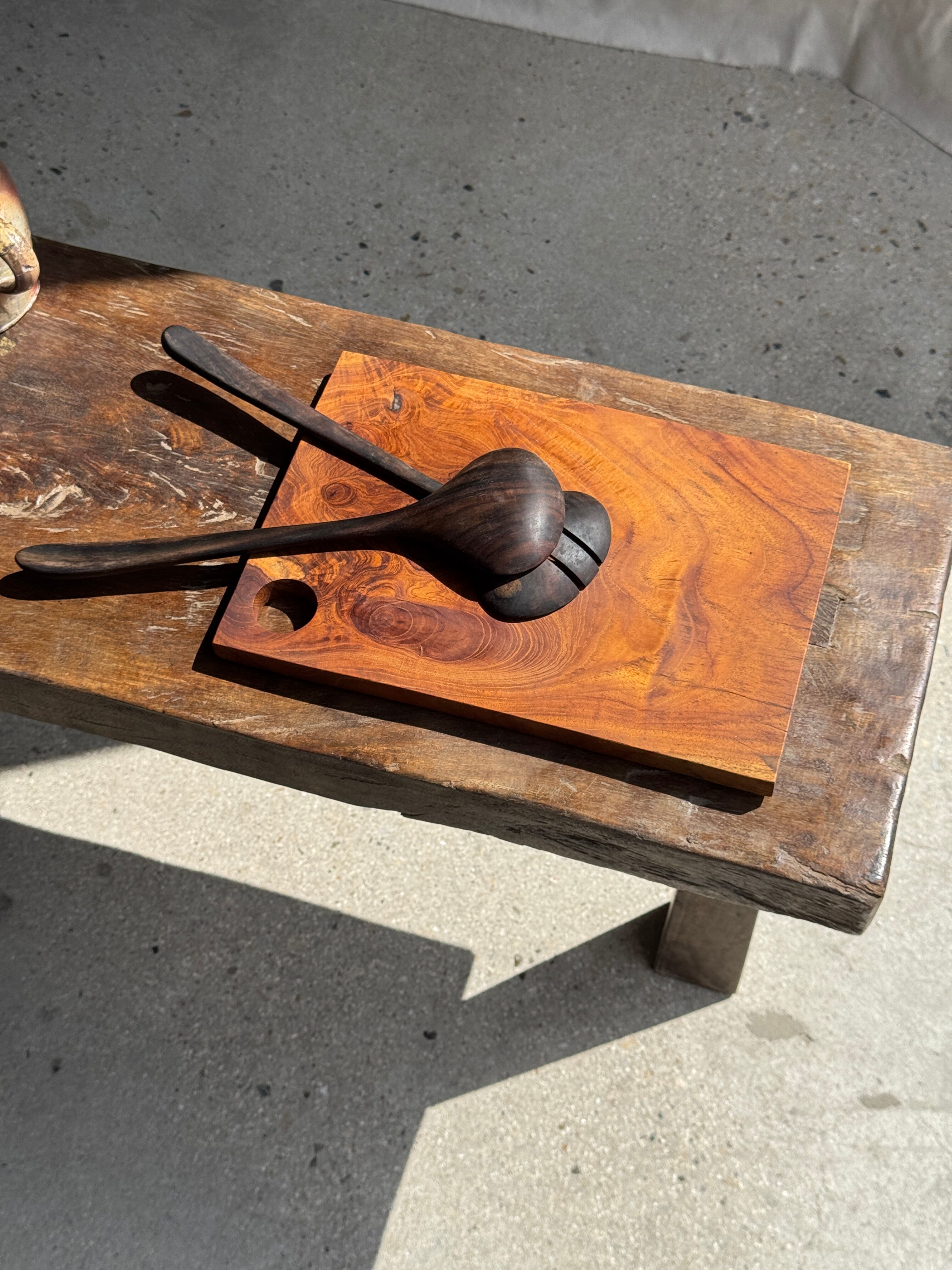 Small rectangular teak monoxyle cutting board with a circular handle.