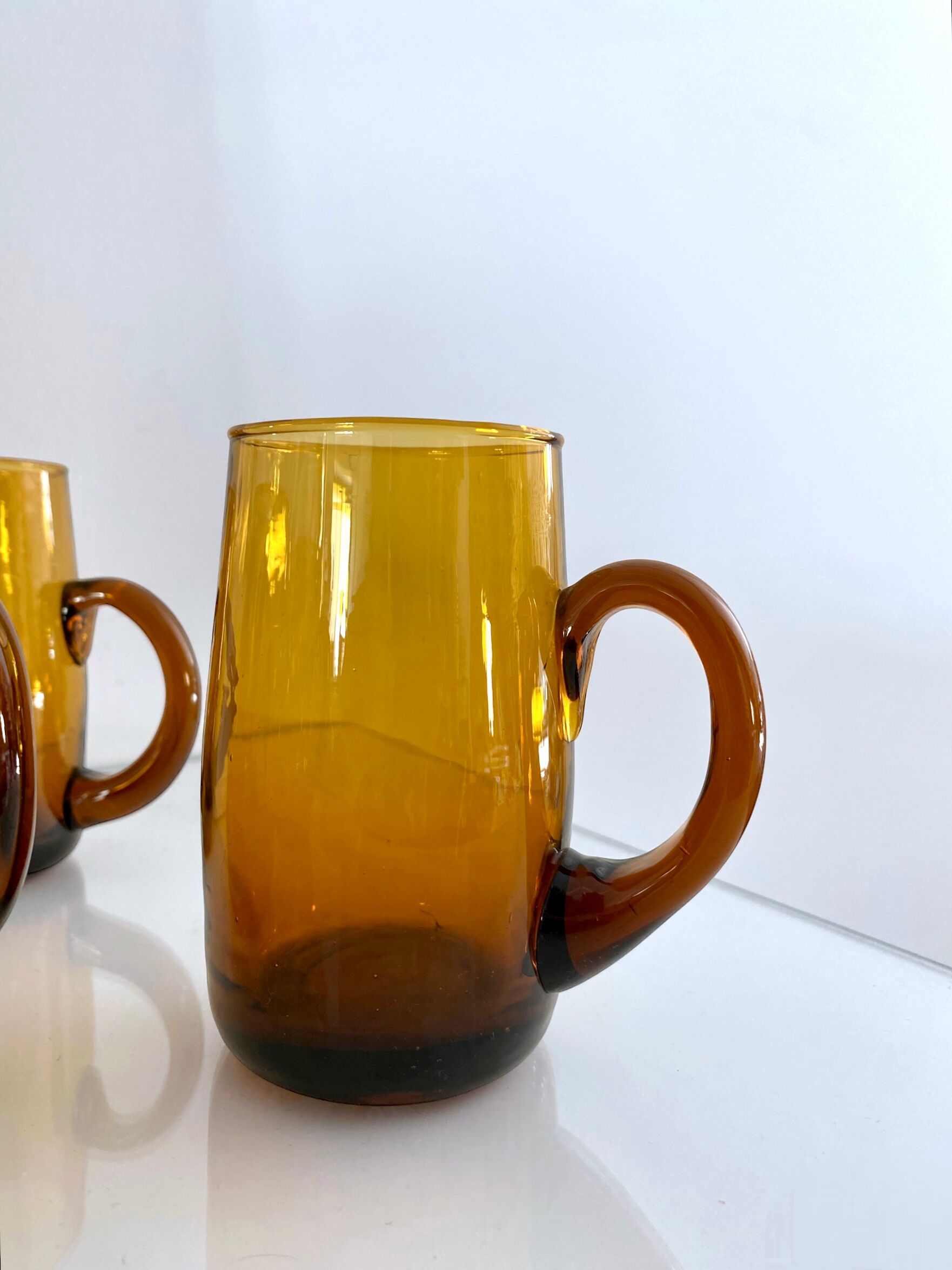 4 mugs/ mugs in vintage blown amber glass