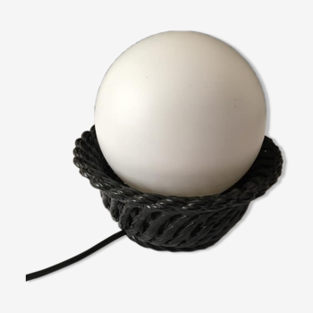 Table lamp with black porcelain support in the shape of a woven basket and opaque glass ball globe