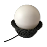 Table lamp with black porcelain support in the shape of a woven basket and opaque glass ball globe