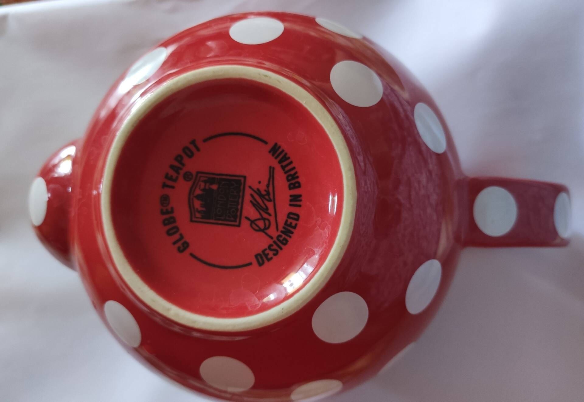 Pretty round English teapot with red polka dots.