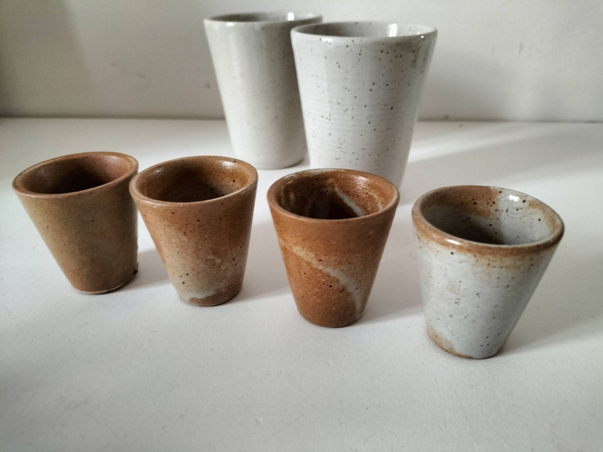 Set of 8 stoneware cups and a mug, shades of beige.