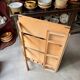 Folding bookshelf in light wood.