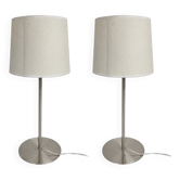 Pair of large brushed metal lamps with cream shades.