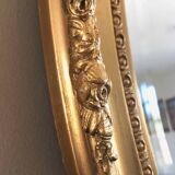 Beveled oval mirror with carved gilded wood frame