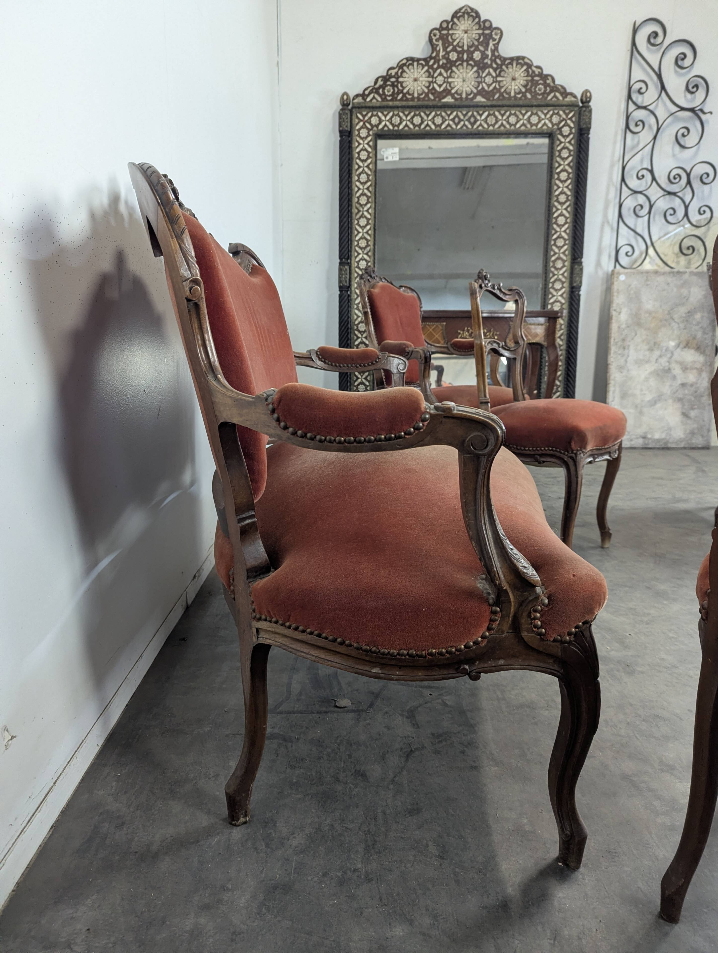 Louis XV style salon in carved walnut with orange velvet, seven pieces.